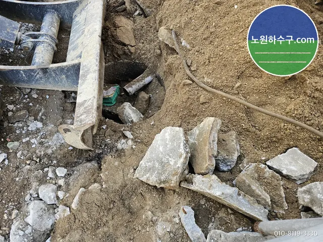 굴착기 버킷 옆 구덩이에 드러난 기존 배관