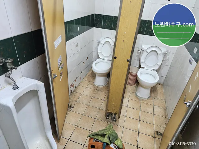 공용화장실 소변기와 좌변기 칸, 바닥에 놓인 장비