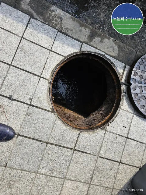 타일 바닥의 원형 배수구를 연 모습